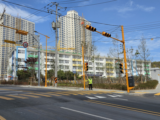 13일 부산 남구 우암2구역 주택재개발 조합에 따르면 지난달 말 조합과 부산경찰청 협의 이후 신연초등 정문에 신호등이 새로 세워졌다. 사진은 정문 앞 설치된 신호등과 현장 교통 지도 모습. 김재량 기자 ryang@