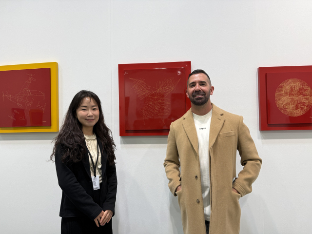 미국 시카고의 한 컬렉터(오른쪽)와 갤러리 화인 관계자가 지난 9~12일 시카고 네이비 피어 페스티벌 홀에서 열린 아트페어 ‘엑스포 시카고 2026’에서 부산 옻칠공예가 최시복 작가의 작품 앞에서 포즈를 취했다. 갤러리 화인 제공