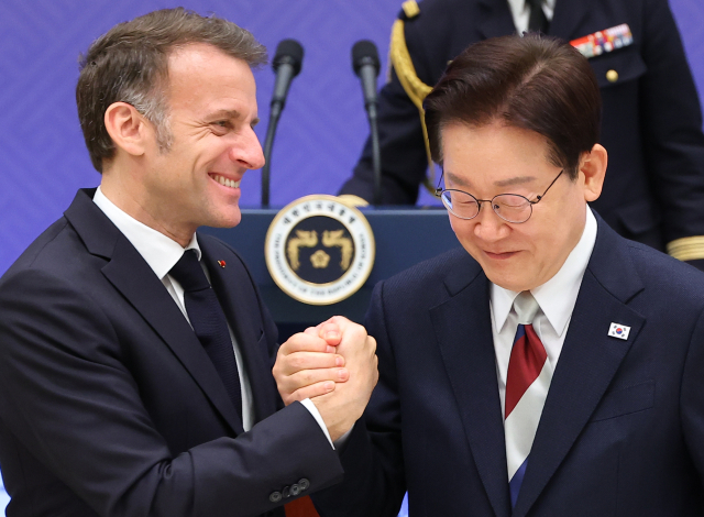 이재명 대통령과 에마뉘엘 마크롱 프랑스 대통령이 3일 청와대에서 열린 국빈 방한 환영 오찬에서 건배 후 손을 맞잡으며 포옹하고 있다. 연합뉴스