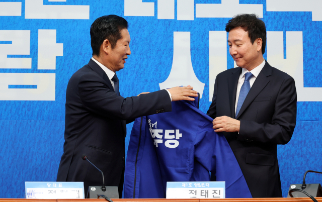 더불어민주당 정청래 대표가 17일 국회에서 열린 1차 인재영입식에서 전태진 변호사에게 당 점퍼를 입혀주고 있다. 전 변호사는 김상욱 의원의 울산시장 선거 출마로 오는 6월 치러지는 울산 남갑 국회의원 보궐선거에 더불어민주당 후보로 출마할 예정이다. 연합뉴스