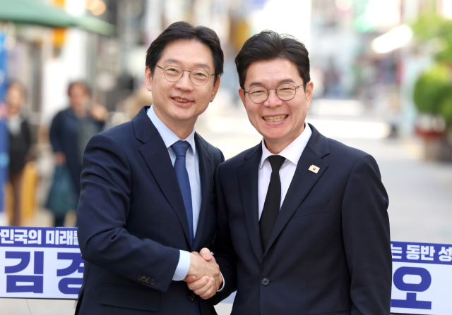 더불어민주당 김경수(왼쪽) 경남지사 후보와 같은 당 정원오 서울시장 후보가 21일 오후 경남 창원시 마산합포구 창동 사거리에서 '서울-경남 상생협력 공동선언' 후 반갑게 악수하고 있다. 연합뉴스