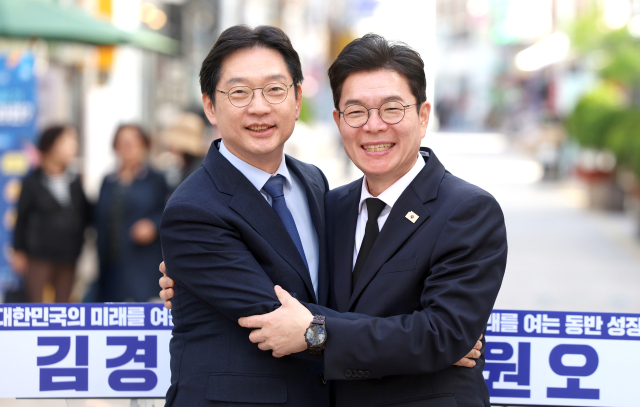 더불어민주당 김경수(왼쪽) 경남지사 후보와 같은 당 정원오 서울시장 후보가 21일 오후 경남 창원시 마산합포구 창동 사거리에서 '서울-경남 상생협력 공동선언' 후 반갑게 인사하고 있다. 연합뉴스