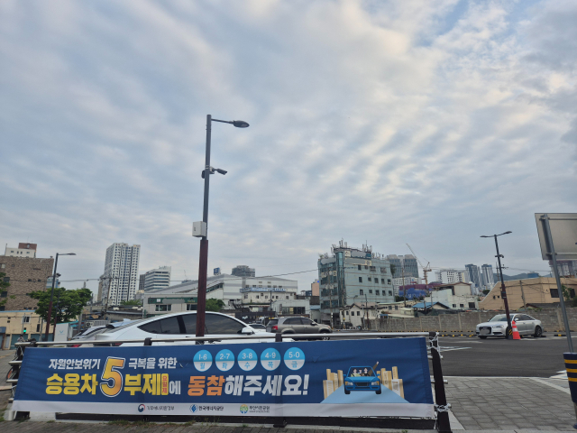 지난 20일 오후 부산 부산진구 부산시민공원 남문 인근의 한 공영주차장에 5부제 시행을 알리는 현수막이 걸려있다. 김동우 기자 friend@