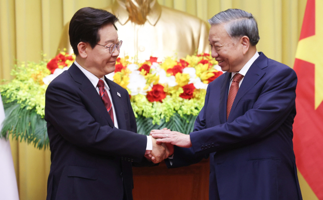 이재명 대통령과 또 럼 베트남 공산당 서기장 겸 국가주석이 22일(현지시간) 하노이 주석궁에서 기념촬영 중 악수하고 있다. 연합뉴스