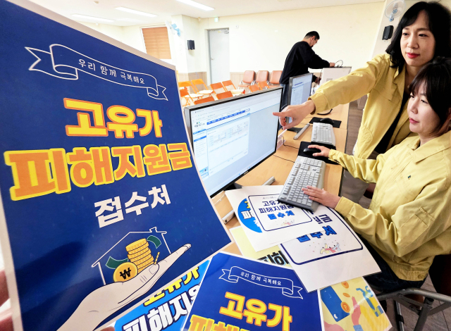 27일부터 기초생활수급자·차상위계층·한부모가족 대상 '고유가 피해지원금' 1차 신청·지급이 시작된다. 지난 24일 광주 북구 용봉동 행정복지센터에서 직원들이 고유가 피해지원금 신청을 받기 위한 접수처 시스템을 점검하는 모습. 연합뉴스