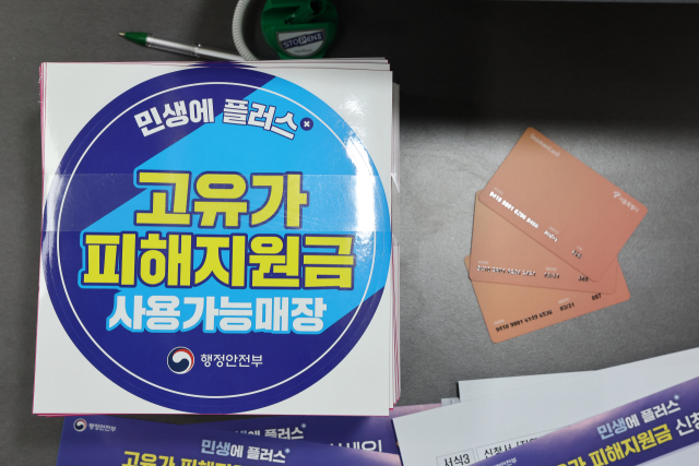 서울 숭인2동주민센터에 마련된 고유가 피해지원금 신청 창구에 관련 부착물과 사용 카드가 놓여 있다. 연합뉴스