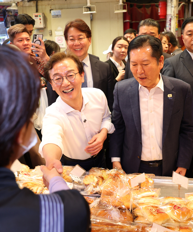 더불어민주당 정청래 대표와 전재수 부산시장 후보가 지난 15일 부산 부산진구 부전시장을 돌며 상인들에게 인사하고 있다. 연합뉴스