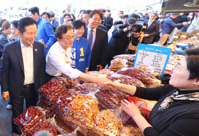 더불어민주당 정청래 대표와 전재수 부산시장 후보, 서은숙 부산진구청장 후보 등이 지난 15일 부산 부산진구 부전시장을 돌며 상인들에게 인사하고 있다. 연합뉴스