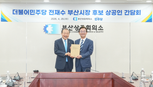 29일 부산상공회의소 회의실에서 부산상의 양재생(왼쪽) 회장이 더불어민주당 전재수 부산시장 후보에게 부산 경제계 건의를 담은 정책 제언집을 전달했다. 부산상공회의소 제공