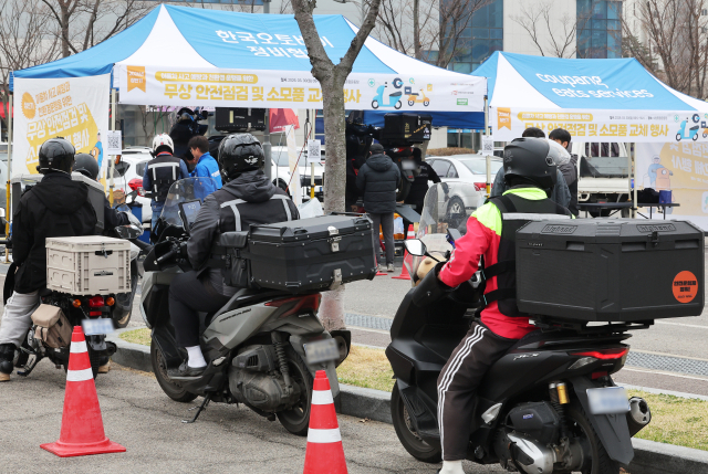 지난 3월 30일 경기도 수원시 장안구 수원종합운동장 주차장에서 열린 '이륜차 사고 예방과 친환경 운행을 위한 무상 안전 점검 및 소모품 교체 행사'에서 관계자들이 오토바이를 점검하고 있다. 연합뉴스