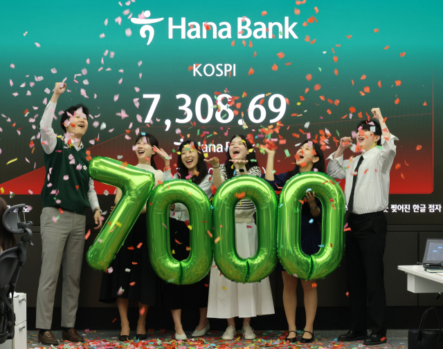 코스피가 7000포인트를 돌파한 6일 서울 중구 하나은행 본점 딜링룸에서 직원들이 축하 세리모니를 하고 있다. 연합뉴스