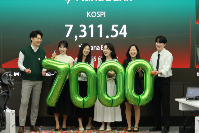 코스피가 7000포인트를 돌파한 6일 서울 중구 하나은행 본점 딜링룸에서 직원들이 축하 세리모니를 하고 있다. 연합뉴스