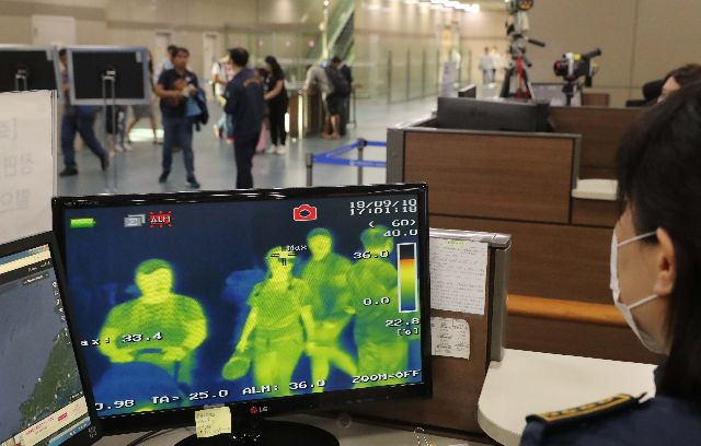 2018년 국내 메르스 환자 유입 당시 김해공항 국제선 입국장에서 입국객들이 체온을 측정하기 위한 열화상카메라 앞을 지나고 있는 모습. 부산일보DB