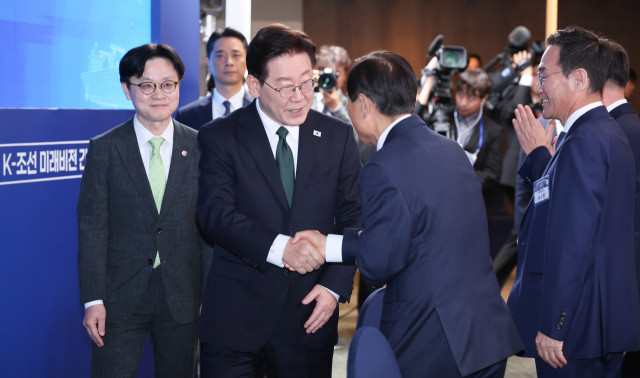 이재명 대통령이 13일 호텔현대 바이 라한 울산에서 열린 K-조선 미래비전 간담회에 입장하며 참석자와 인사하고 있다. 연합뉴스