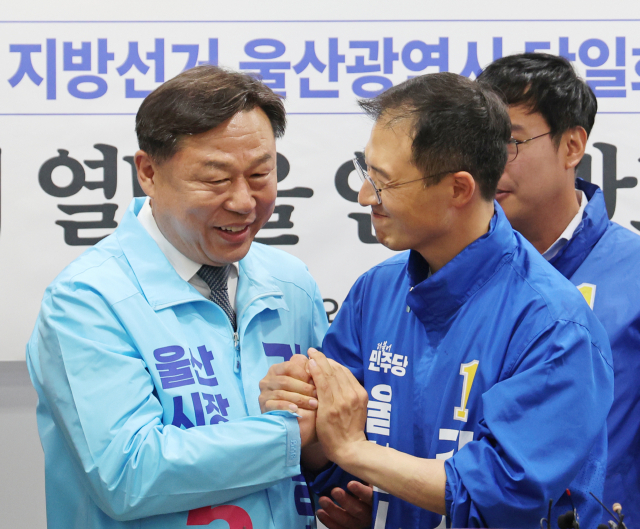 지난 15일 울산시의회 프레스센터에서 더불어민주당 울산시당과 진보당 울산시당이 6·3 지방선거 울산시장 후보 단일화 합의를 발표한 후 민주당 김상욱(오른쪽)·진보당 김종훈 울산시장 후보가 손을 맞잡고 있다. 연합뉴스