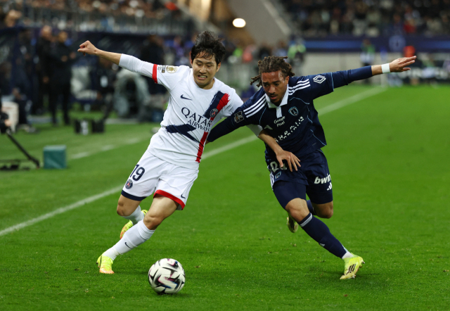 부상에서 회복한 이강인(PSG)이 18일(한국 시간) 프랑스 파리에서 열린 파리FC와의 리그1 최종전에서 상대 선수와 볼 다툼을 벌이고 있다.로이터연합뉴스