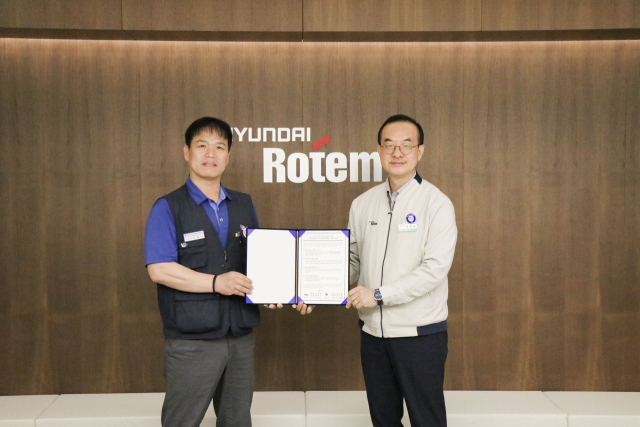 김익수(오른쪽) 현대로템 경영지원본부장과 남봉희 전국금속노동조합 현대로템 지회장이 지난 19일 현대로템 창원공장에서 열린 동반성장 노사미래전략TFT 발족식에서 기념촬영을 하고 있다. 현대로템 제공