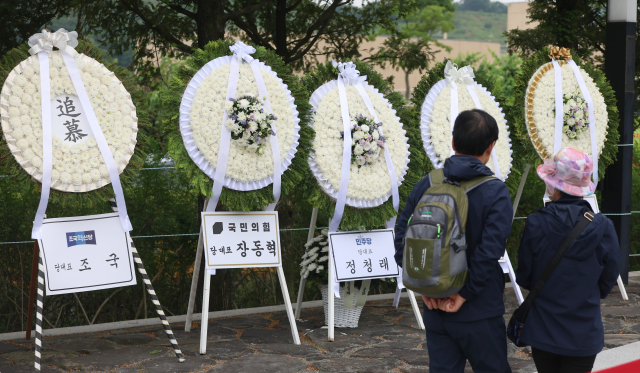 노무현 전 대통령 17주기 추도식이 거행되는 23일 오전 경남 김해시 진영읍 봉하마을에 더불어민주당 정청래 대표, 국민의힘 장동혁 대표, 조국혁신당 조국 대표가 보낸 조화가 놓여있다. 연합뉴스