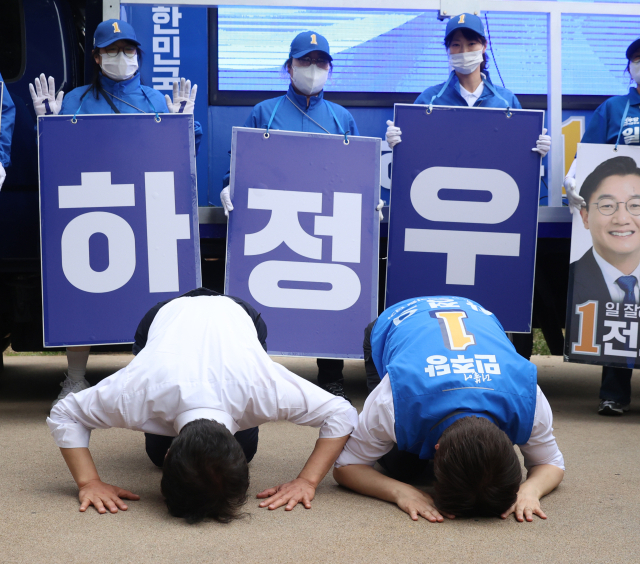 더불어민주당 전재수 부산시장 후보와 하정우 북갑 국회의원 보궐선거 후보가 23일 오후 부산 북구 구포시장 쌈지공원에서 합동유세에 앞서 큰절을 하고 있다. 연합뉴스