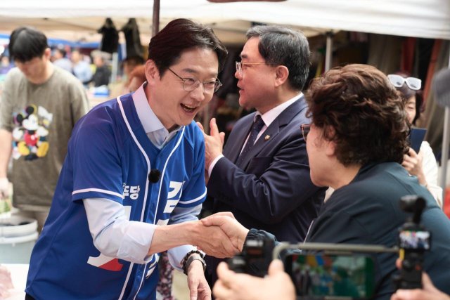 24일 창원 마산합포구 신마산 번개시장을 찾은 민주당 김경수 경남지사 후보가 도민과 악수를 나누고 있다. 민주당 제공