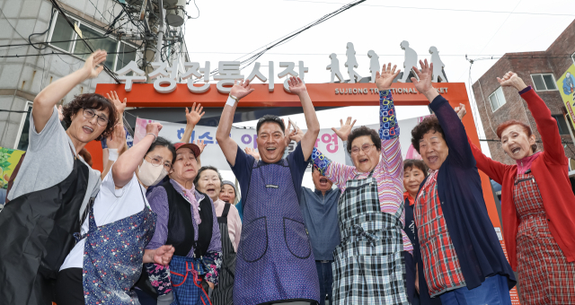 부산 동구 수정동 수정전통시장은 점포 87개 규모의 작은 시장이다. 최근 시장 활성화를 위한 변화를 꾀하고 있는 상인들이 함께 만세를 외치고 있다. 김종진 기자 kjj1761@
