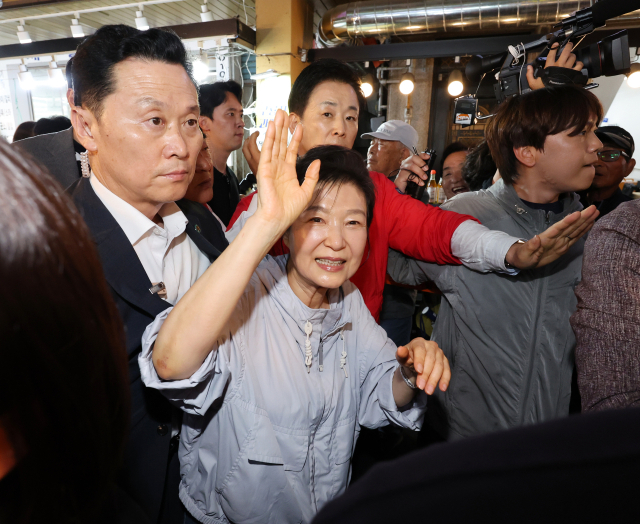 박근혜 전 대통령이 27일 울산시 남구 신정시장을 방문해 시민에게 손을 들어 인사하고 있다. 연합뉴스