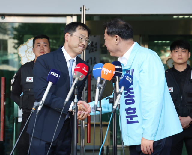 28일 울산시 중구 울산시선거관리위원회 앞에서 더불어민주당 김상욱(왼쪽), 진보당 김종훈 울산시장 후보가 김상욱 후보로의 단일화를 발표한 후 악수하고 있다. 연합뉴스
