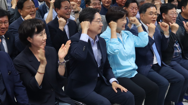 더불어민주당 김경수(가운데) 경남지사 후보가 3일 경남 창원시 성산구 선거사무소에서 방송 3사 출구 조사 결과를 확인하고 주먹을 불끈 쥐고 있다. 최환석 기자