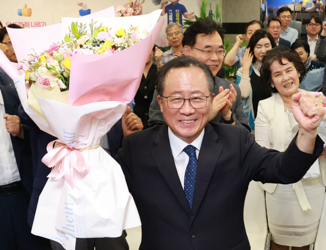 김석준 부산시교육감 후보가 3일 오후 부산 부산진구 선거사무소에서 당선이 확실시되자 꽃다발을 들고 환하게 웃고 있다. 연합뉴스