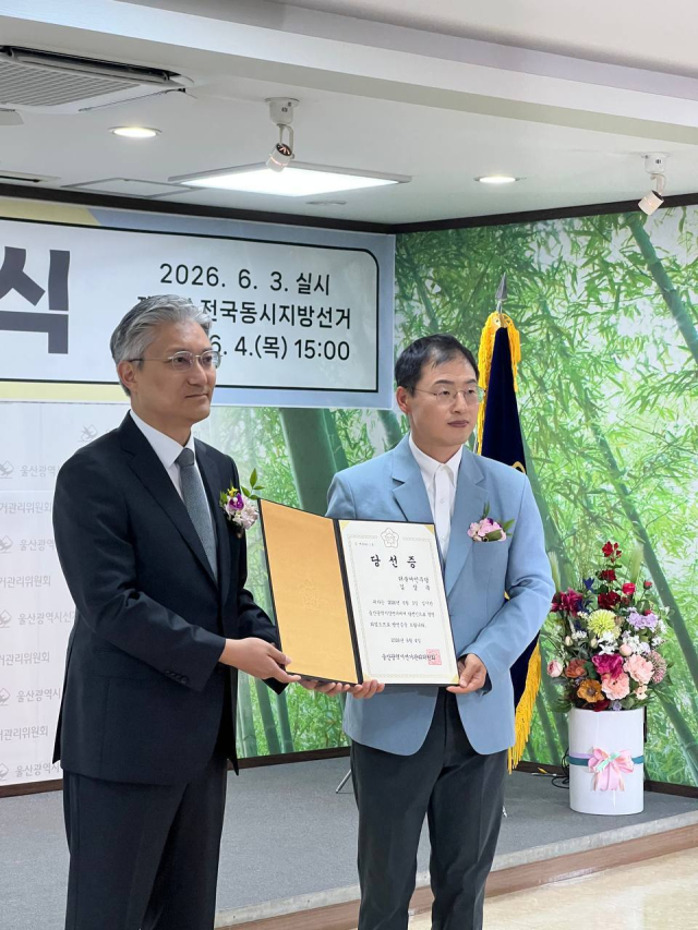 6·3 지방선거에서 울산시장에 당선된 더불어민주당 김상욱 당선인(오른쪽)이 4일 울산시선거관리위원회에서 당선증을 교부받고 있다. 김상욱 당선인 측 제공