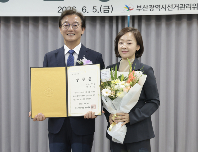 전재수 부산시장 당선인이 지난 5일 부산 연제구 부산시선관위에서 열린 당선증 교부식에서 배우자 최혜진씨와 함께 기념촬영을 하고 있다. jhyun@