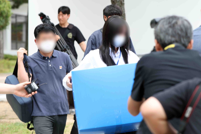 경남도청 압수수색을 마친 경찰이 9일 압수품을 들고 도청사를 나서고 있다. 경찰은 6·3지방선거 과정에서 불거진 국민의힘 박완수 경남지사 당선인 캠프 측의 '딥페이크 영상·관권선거 의혹'과 관련해 이날 강제수사에 착수했다. 연합뉴스