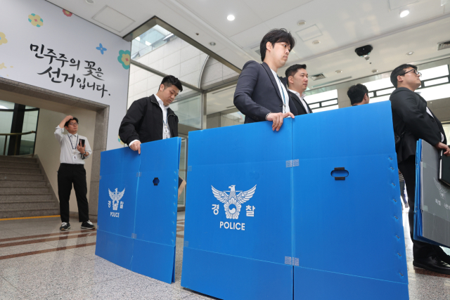 경찰 관계자들이 11일 경기도 과천시 중앙선거관리위원회에서 6·3 지방선거 투표지 부족사태 관련 압수수색을 위해 이동하고 있다. 연합뉴스
