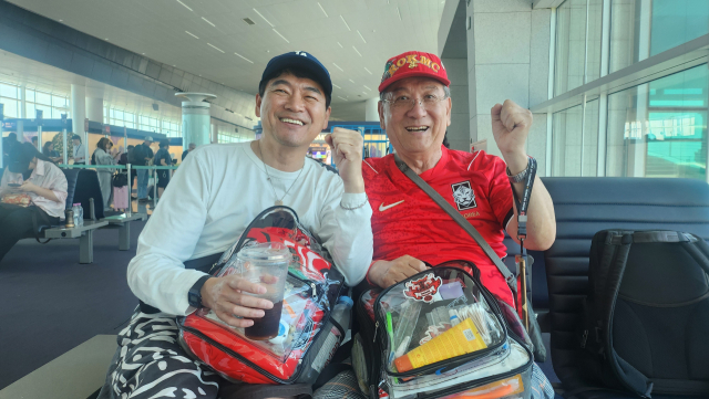 지난 9일 멕시코 출국 전 인천공항에서 파이팅을 외치고 있는 부산지역 붉은 악마의 맏형 김만식(오른쪽) 씨와 '직관 친구' 홍성무 씨.
