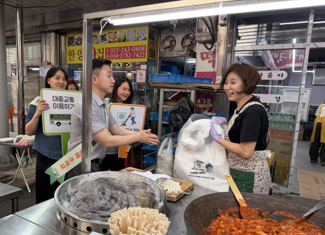 한국동서발전 직원들이 태화종합시장 식당가를 방문해 '에너지 절약 국민행동' 앞치마를 상인들에게 전하고 있다. 동서발전 제공