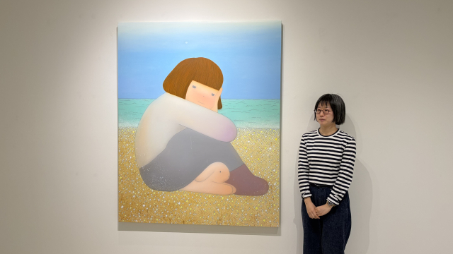 카린 갤러리에서 열리고 있는 '우리는 바다를 믿기로 했다'(2025) 작품 앞에서 포즈를 취한 김한나 작가. 김은영 기자 key66@