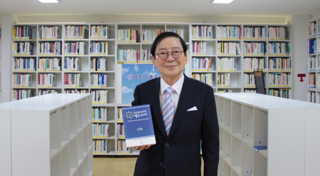 부산국제장애인협의회 강충걸 회장이 AI를 활용해 장애인들이 그린 삽화를 수록한 감사 명언집 ‘땡스 1,000’ 을 들고 기념촬영하고 있다. 부산국제장애인협의회 제공