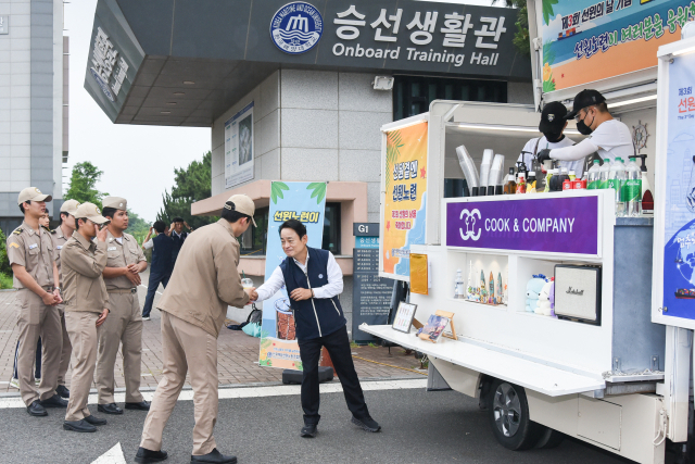제3회 선원의 날을 맞아 지난 19일 오전 부산 한국해양대학교 승선생활관 앞에서 열린 선원노련 커피차 이벤트에서 김두영 선원노련 위원장이 학생들에게 직접 음료를 전달하며 응원의 메시지를 전하고 있다. 선원노련 제공