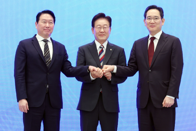 이재명 대통령과 이재용 삼성전자 회장, 최태원 SK그룹 회장이 29일 청와대에서 열린 3대 메가프로젝트 국민보고회에서 기업 투자계획 발표 후 손을 잡고 있다. 연합뉴스