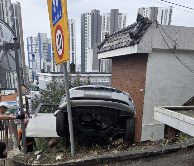 2일 오전 10시 20분께 동구 수정동 한 복지회관 앞 도로에서 20대 여성 A 씨가 몰던 승용차가 후진하던 중 2m가량 아래 주택가로 추락했다. 부산 동부경찰서 제공.