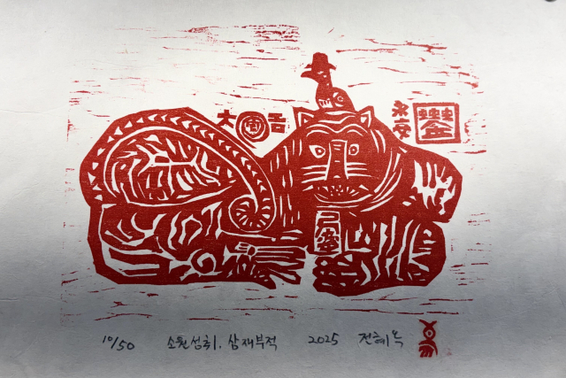 전혜옥 목판화 '소원성취, 삼재부적'(2025). 전통 부적 판화에 '케이팝 데몬 헌터스'의 갓을 쓴 까치가 올라가 있는 모습이다. 김은영 기자 key66@