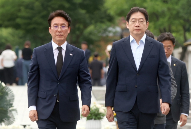 더불어민주당 당권주자인 김민석 전 국무총리가 지난 17일 경남 김해시 진영읍 봉하마을 노무현 전 대통령 묘역으로 향하고 있다. 오른쪽은 김경수 전 경남지사. 연합뉴스