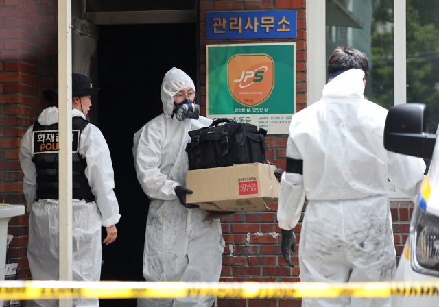 23일 오전 8시 29분께 경북 경산시 사동 한 아파트 관리실 안에서 폭발 추정 사고가 난 가운데 경찰 과학수사대가 증거물로 보이는 물건을 담은 종이상자를 가지고 철수하고 있다. 연합뉴스