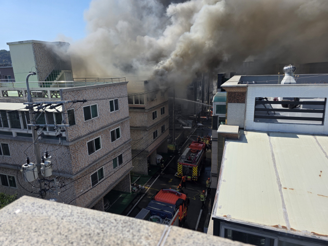 3일 오전 울산 남구 삼산동 원룸촌의 한 건물에서 화재가 발생해 짙은 회색 연기가 하늘로 치솟는 가운데, 소방대원들이 진화 작업에 진땀을 흘리고 있다. 오상민 기자
