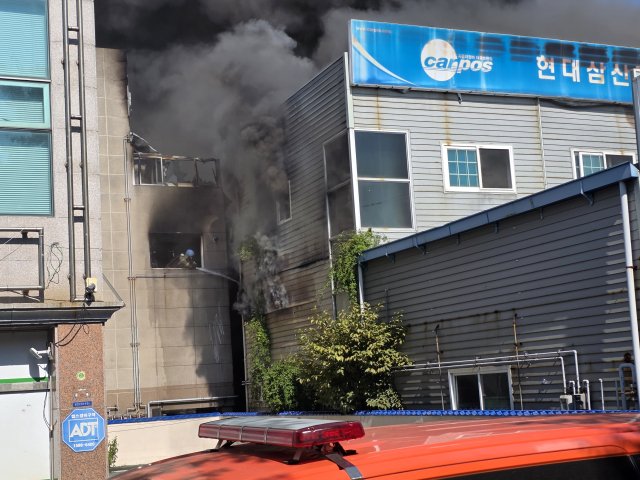 3일 오전 울산 남구 삼산동 화재 현장에서 페인트 공장에 난 불이 인근 건물로 옮겨붙어 외벽이 시커멓게 그을려 있다. 출동한 소방대원들이 건물 사이로 치솟는 연기를 살피며 진화 작업을 벌이고 있다. 오상민 기자