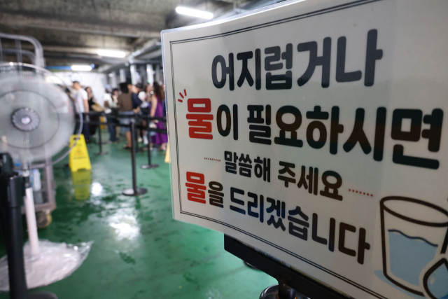 4일 대전 중구 성심당 매장 앞 대기 줄이 북적이는 가운데, 대기 공간에 온열질환 예방을 위한 생수 제공 안내판과 대형 선풍기가 설치돼 있다. 연합뉴스
