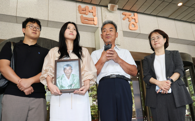일본제철 강제동원 피해자 고 민문식 씨의 장남 민병조(오른쪽 두번째) 씨와 손녀 민사라 씨가 12일 서울 서초구 대법원에서 열린 일본제철 강제동원 손해배상 청구소송 상고심 선고를 마치고 나와 입장을 밝히고 있다. 연합뉴스