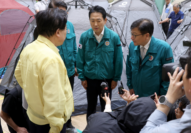 국민의힘 장동혁 대표(가운데)와 정점식 원내대표가 18일 오전 경남 거제시 옥포초등학교에 마련된 호우 피해 주민 임시 대피시설을 찾아 피해 대한적십자사 관계자의 설명을 듣고 있다. 연합뉴스