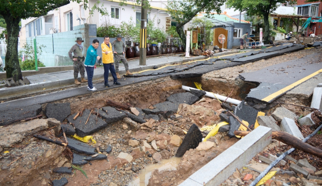 강석주 통영시장 극한 호우에 진입도로 양방향이 뜯긴 봉숫골 피해 현장을 확인하고 있다. 부산일보DB