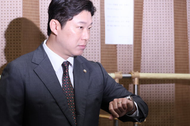 국민의힘 진종오 의원이 21일 윤리위원회의 당원권 정지 결정과 관련해 기자회견을 하기 위해 국회 소통관으로 들어가며 시간을 확인하고 있다. 연합뉴스